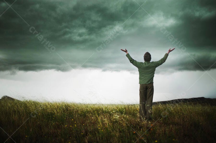 Homem em campo sob tempestade escura