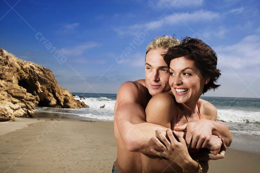 Casal abraçado na praia ensolarada