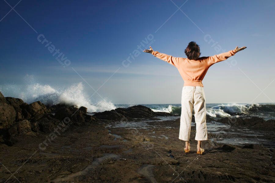 Mulher contemplando o mar em dia ensolarado