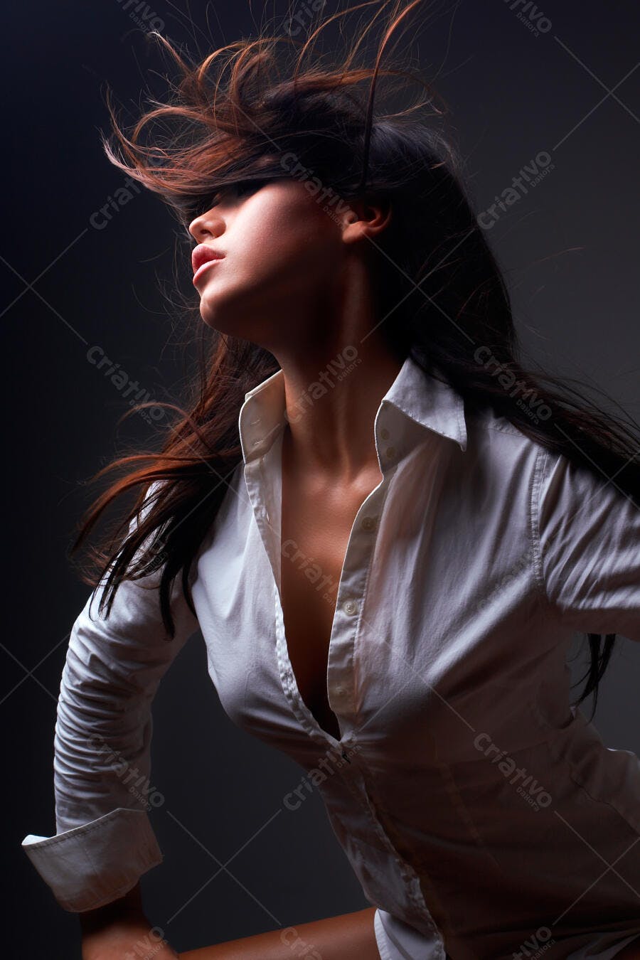 Mulher cabelos escuros camisa branca vento
