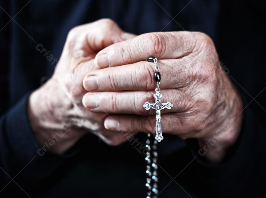 Mãos com terço prata e crucifixo