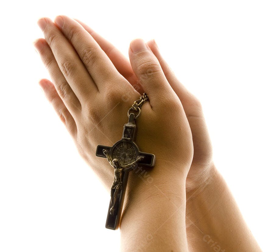 Mãos em oração com crucifixo