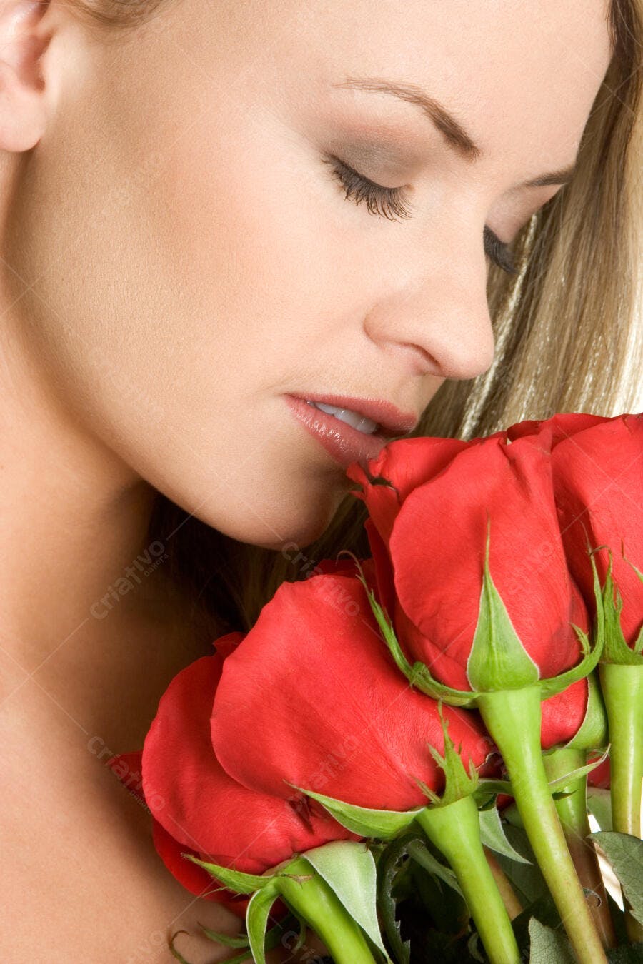 Mulher cheirando rosas vermelhas