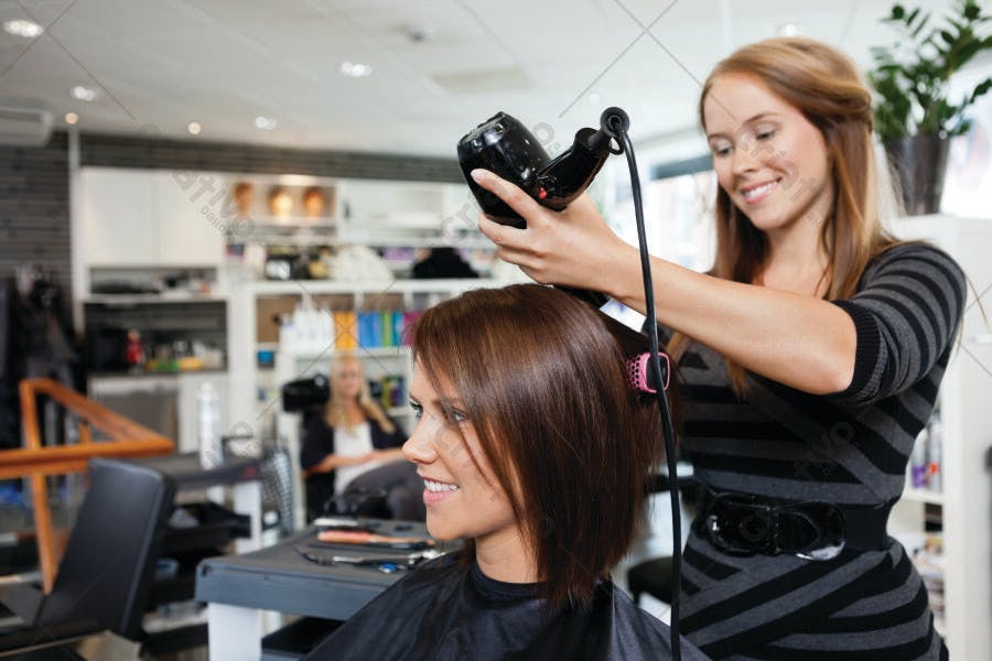 Estilista secando cabelo castanho em salão