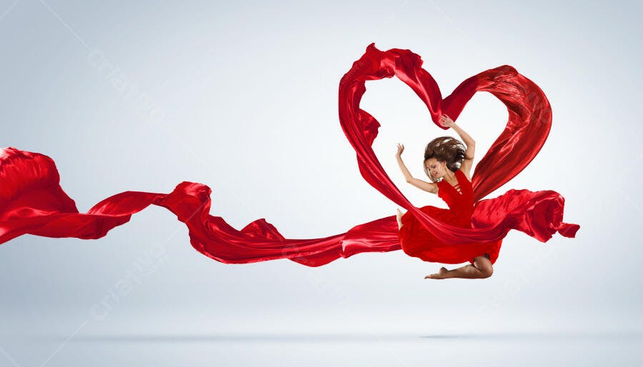 Bailarina em vestido vermelho saltando com tecido em forma de coração