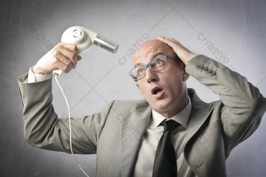 Homem careca usando secador de cabelo com expressão de surpresa