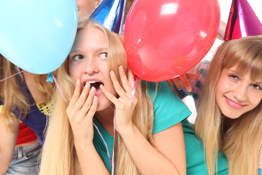 Amigas em festa com balões e chapéus