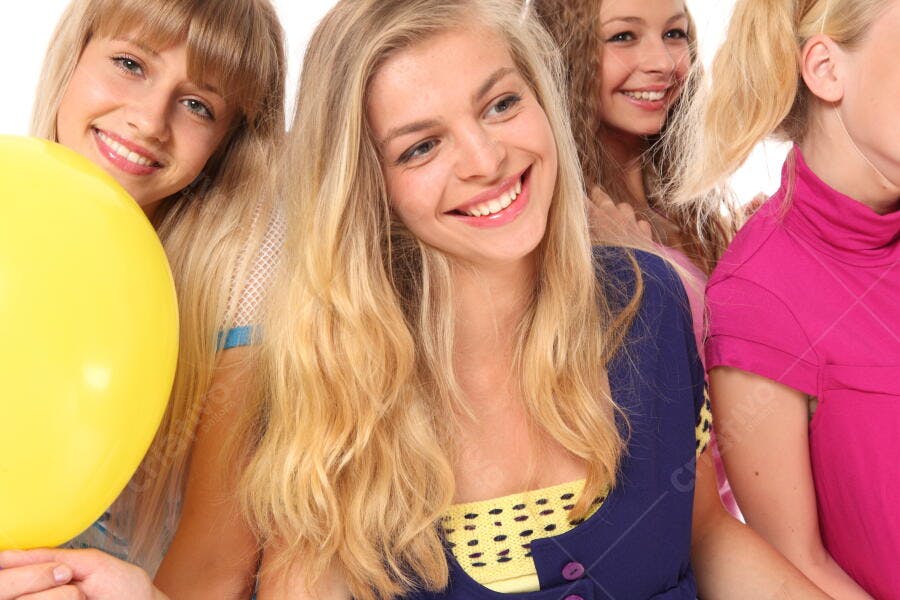Amigas adolescentes sorrindo com balão amarelo