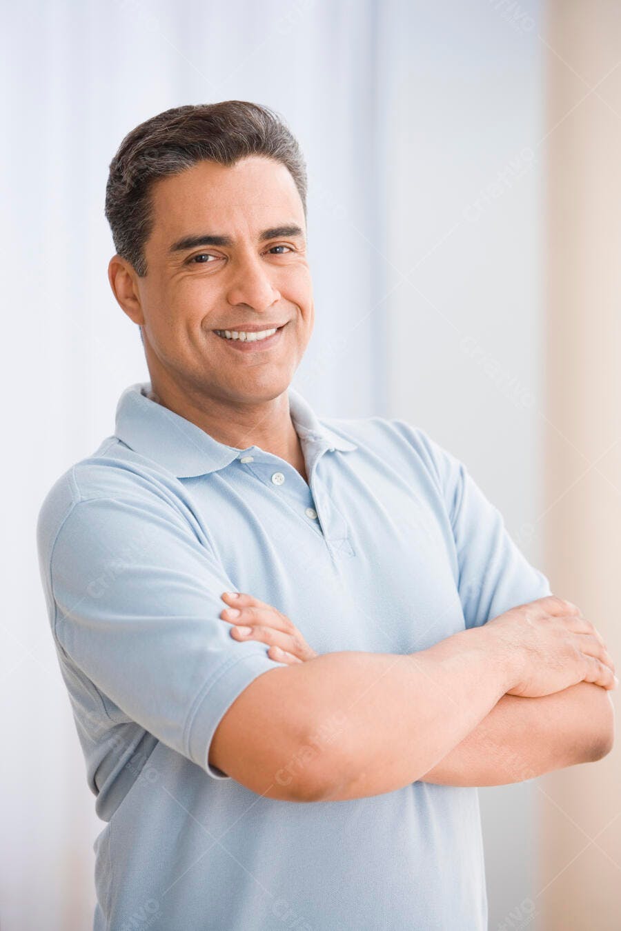 Homem latino sorrindo braços cruzados