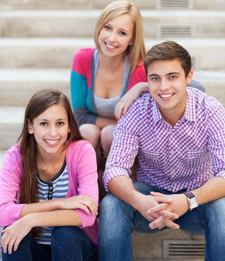 Três jovens amigos sorrindo em escada
