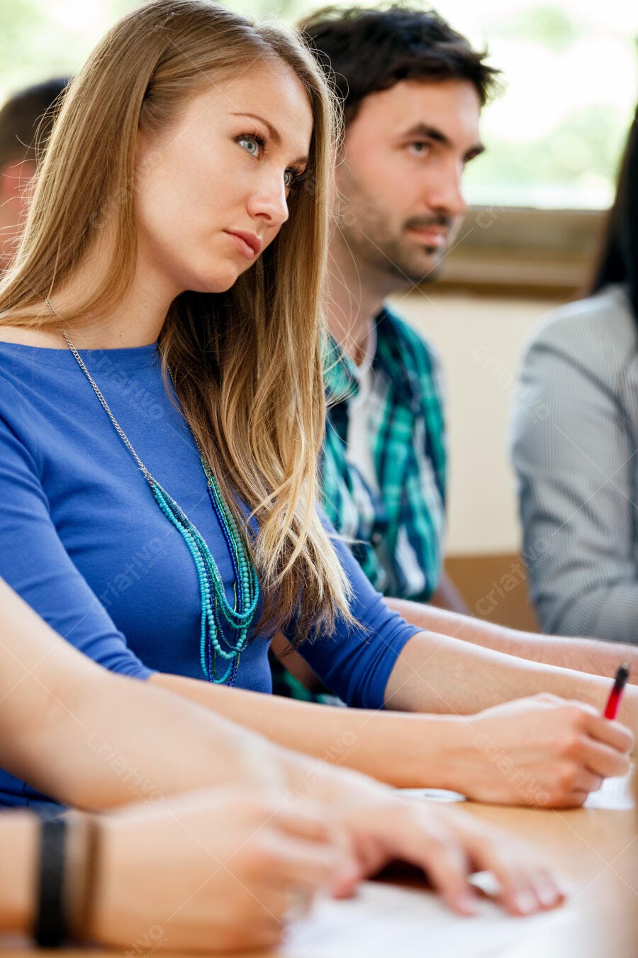 Estudantes em sala de aula anotando
