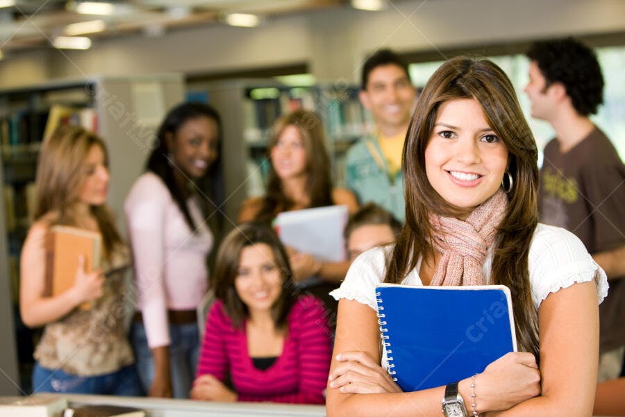 Estudante sorridente com colegas na biblioteca