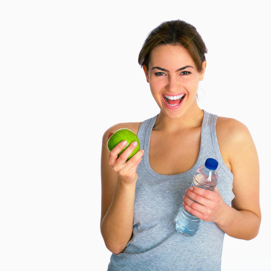 Mulher sorridente com maçã verde e água