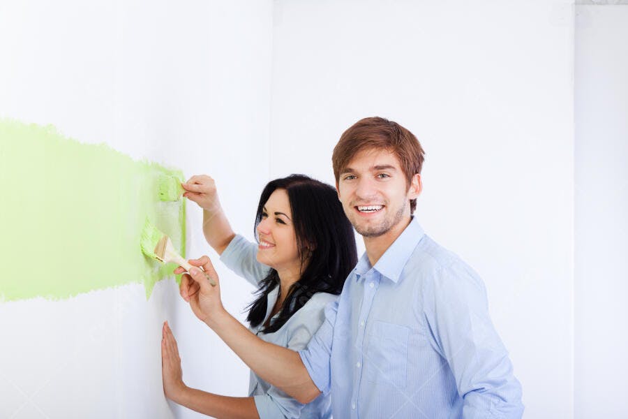 Casal pintando parede verde claro