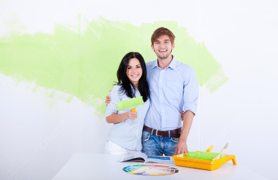 Casal pintando parede verde claro