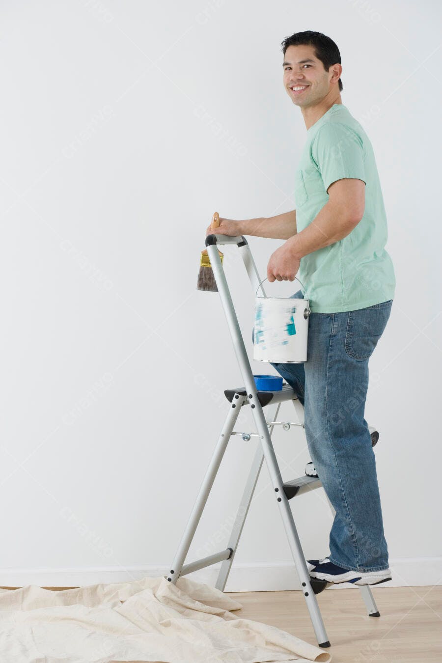 Homem sorrindo pintando parede em casa