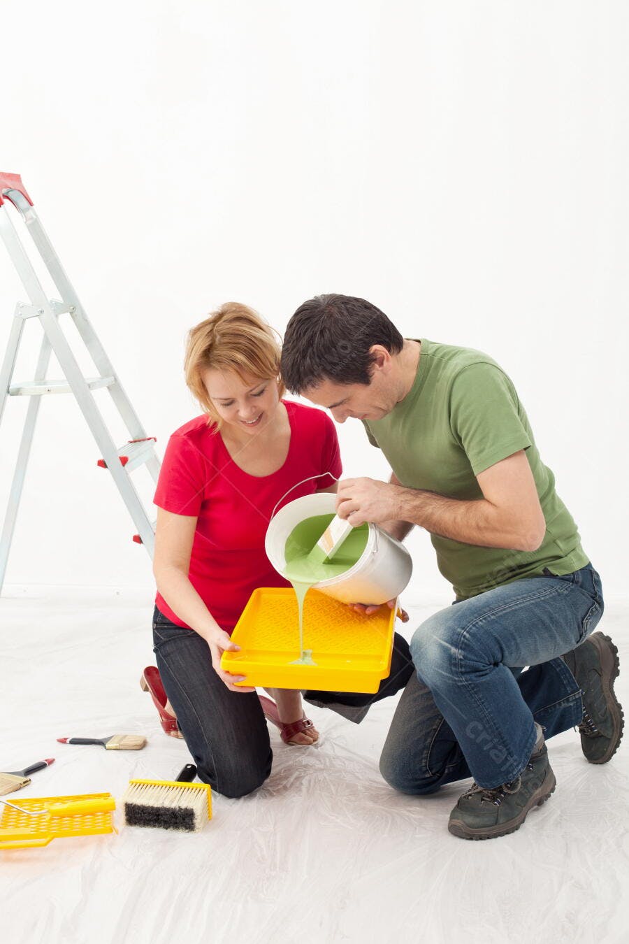 Casal pintando parede com tinta verde