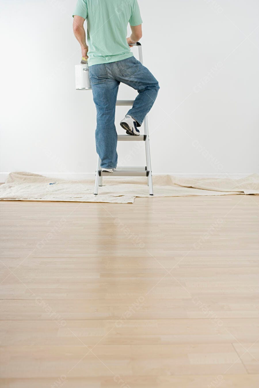Homem pintando parede em escada