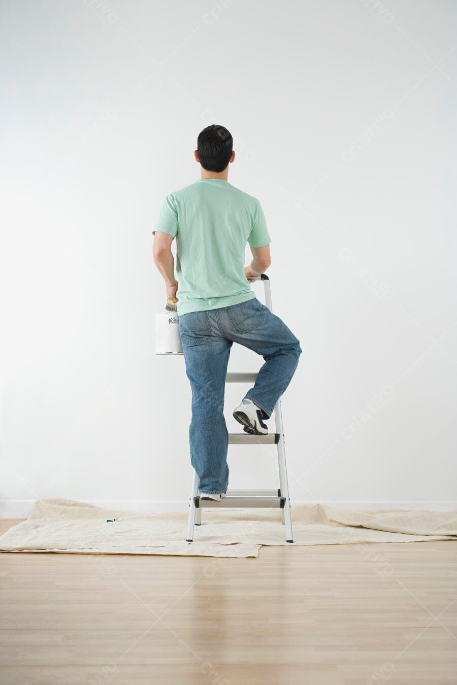 Homem pintando parede em escada