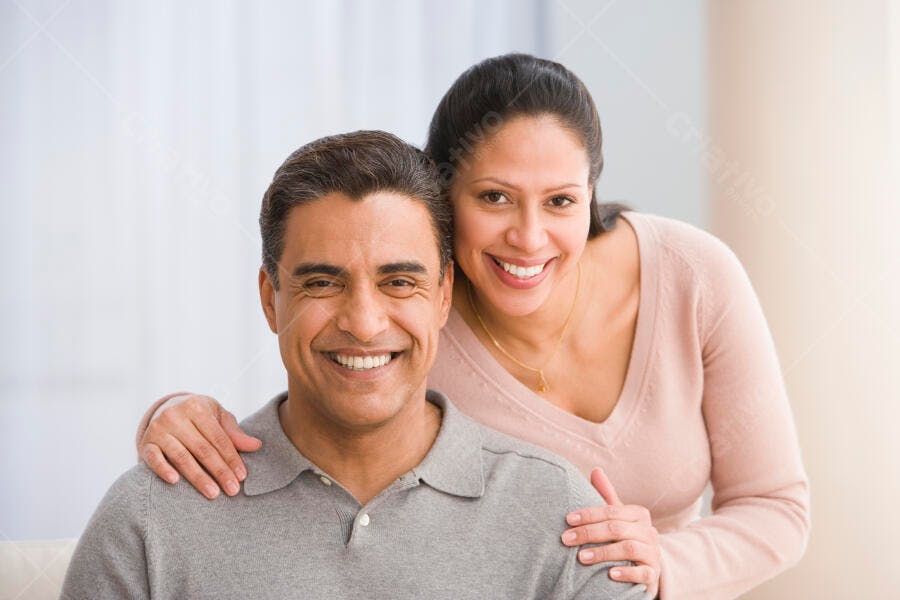 Casal hispânico sorrindo em casa