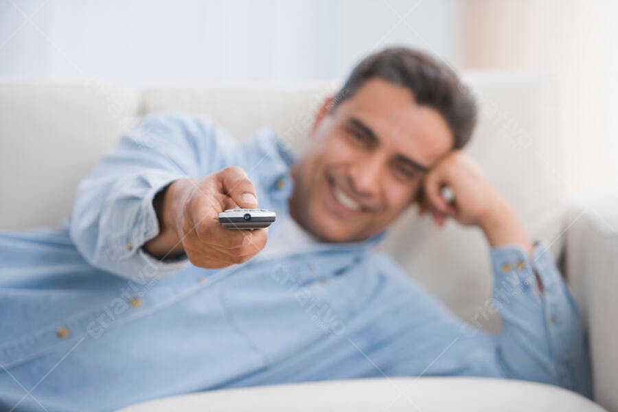 Homem sorrindo com controle remoto na mão
