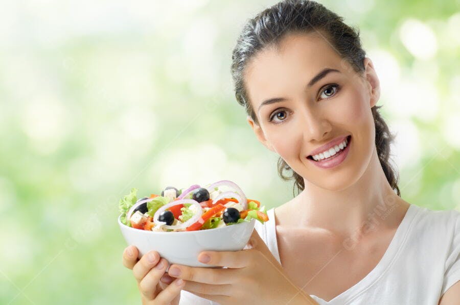 Mulher sorridente segurando salada fresca