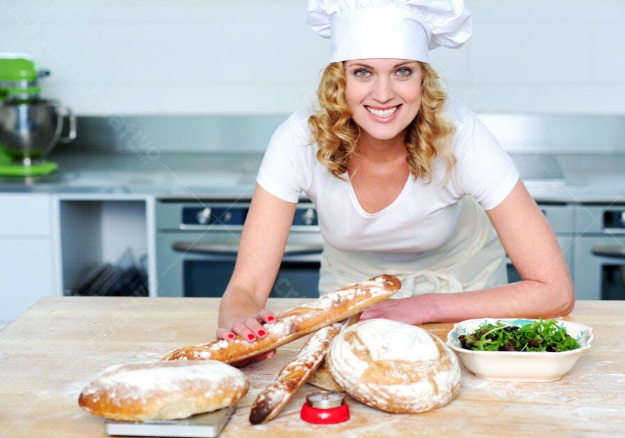 Padeira sorridente com pães frescos e salada