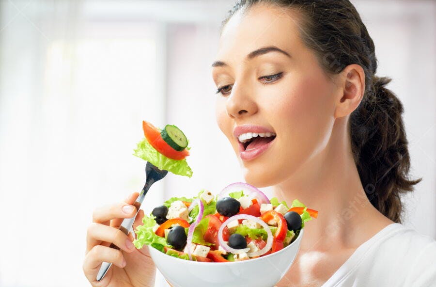 Mulher comendo salada fresca e colorida