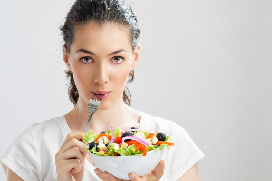 Mulher comendo salada fresca e colorida