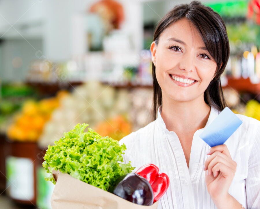 Mulher sorrindo com compras no supermercado