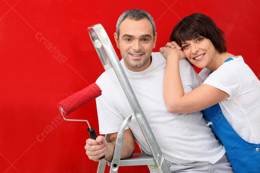 Casal de pintores sorrindo fundo vermelho
