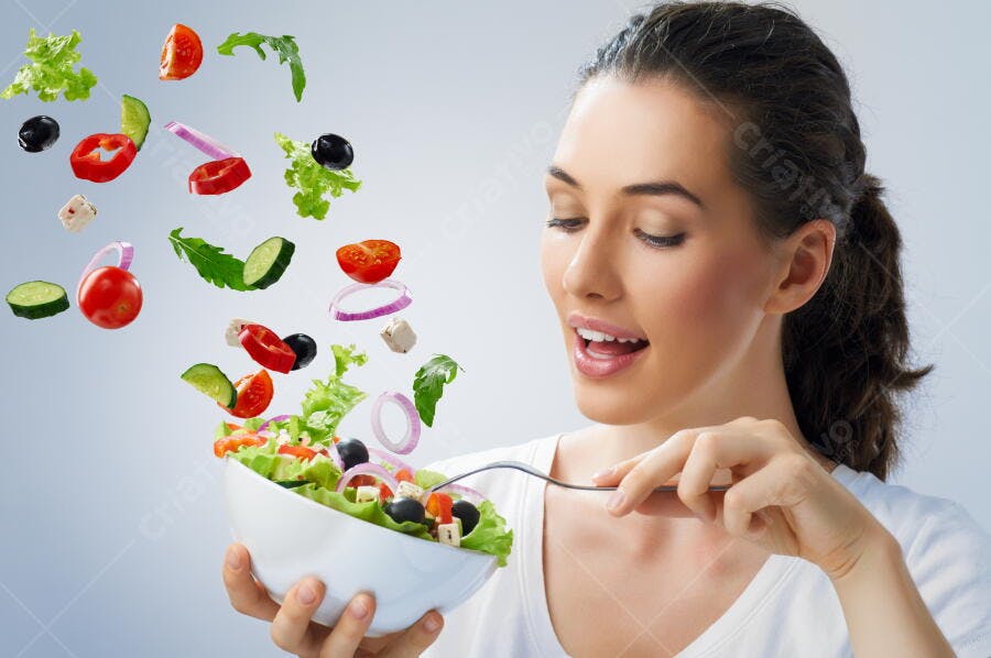 Mulher comendo salada colorida ingredientes no ar