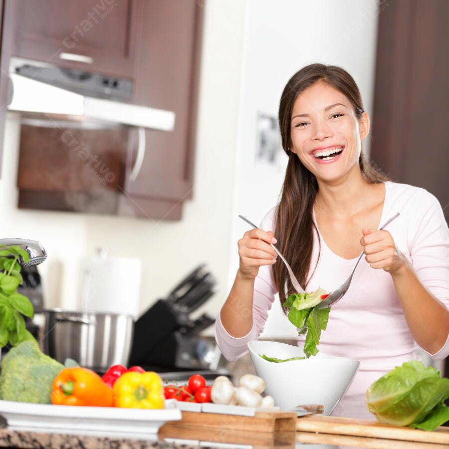 Mulher feliz preparando salada na cozinha