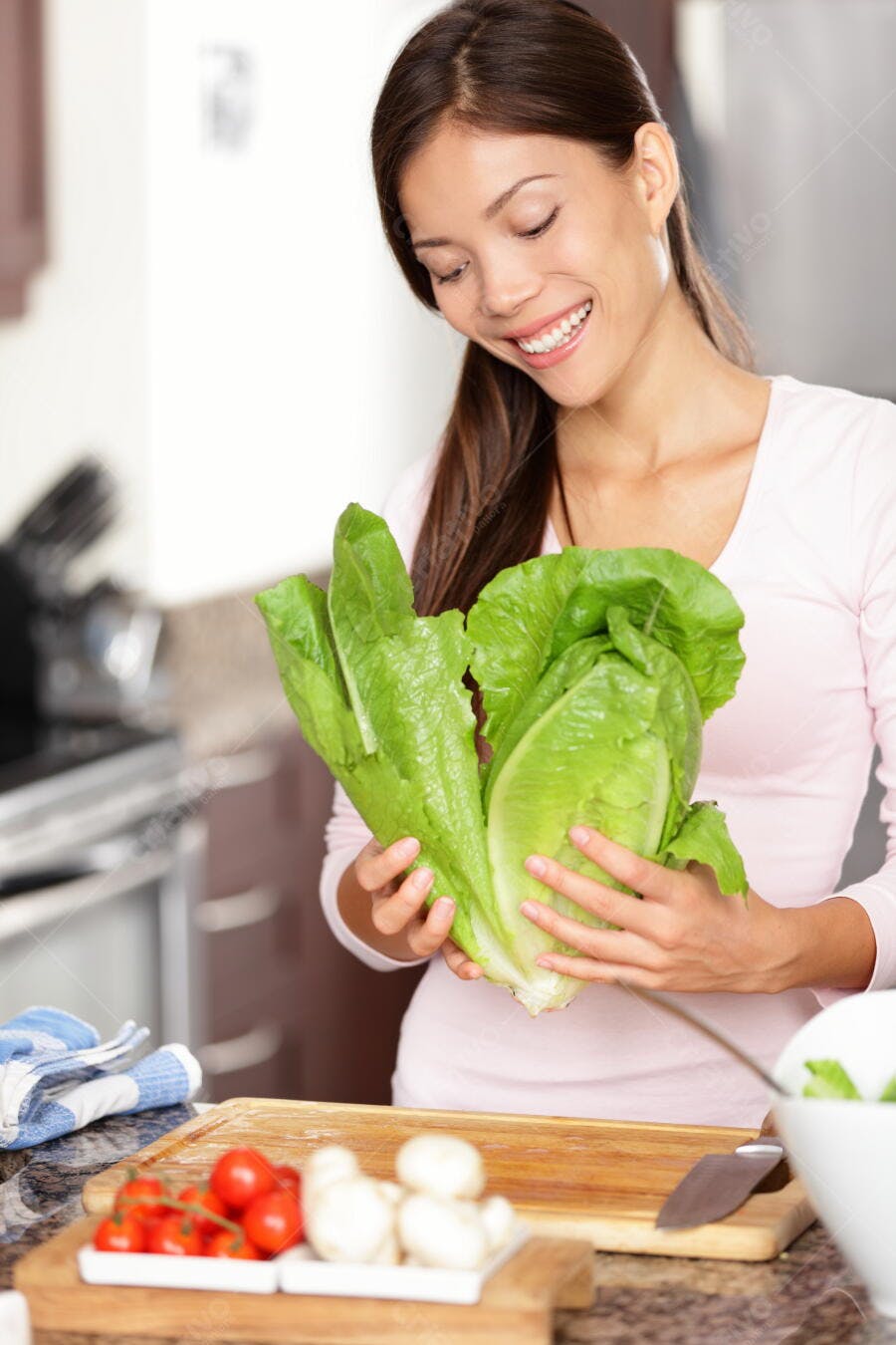 Mulher asiática preparando salada na cozinha
