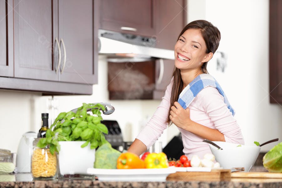 Mulher asiática feliz cozinhando na cozinha