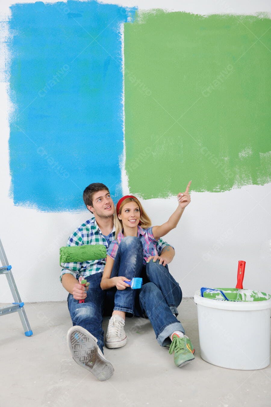 Casal pintando parede azul e verde