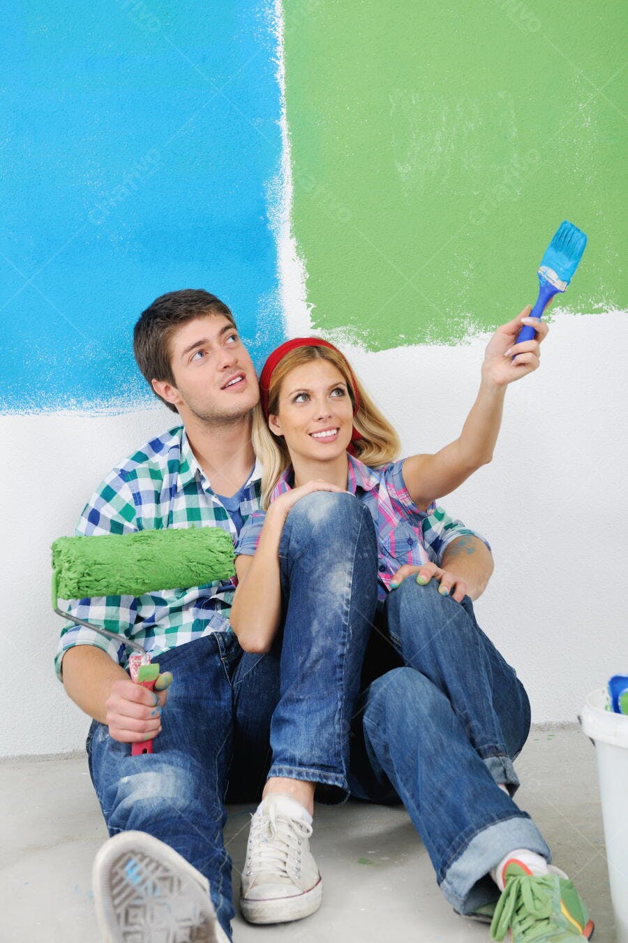 Casal pintando parede azul e verde