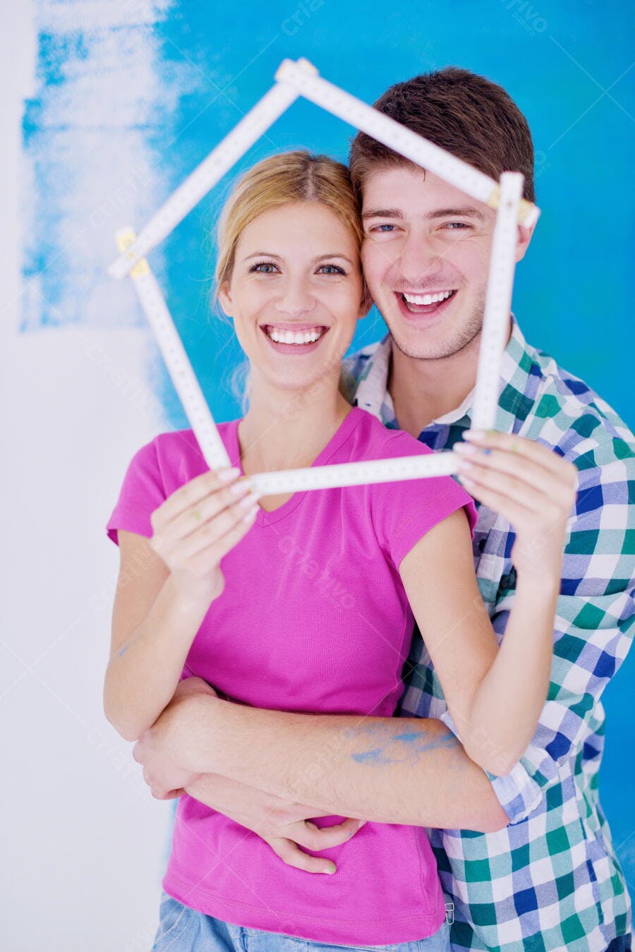 Casal feliz com trena em forma de casa