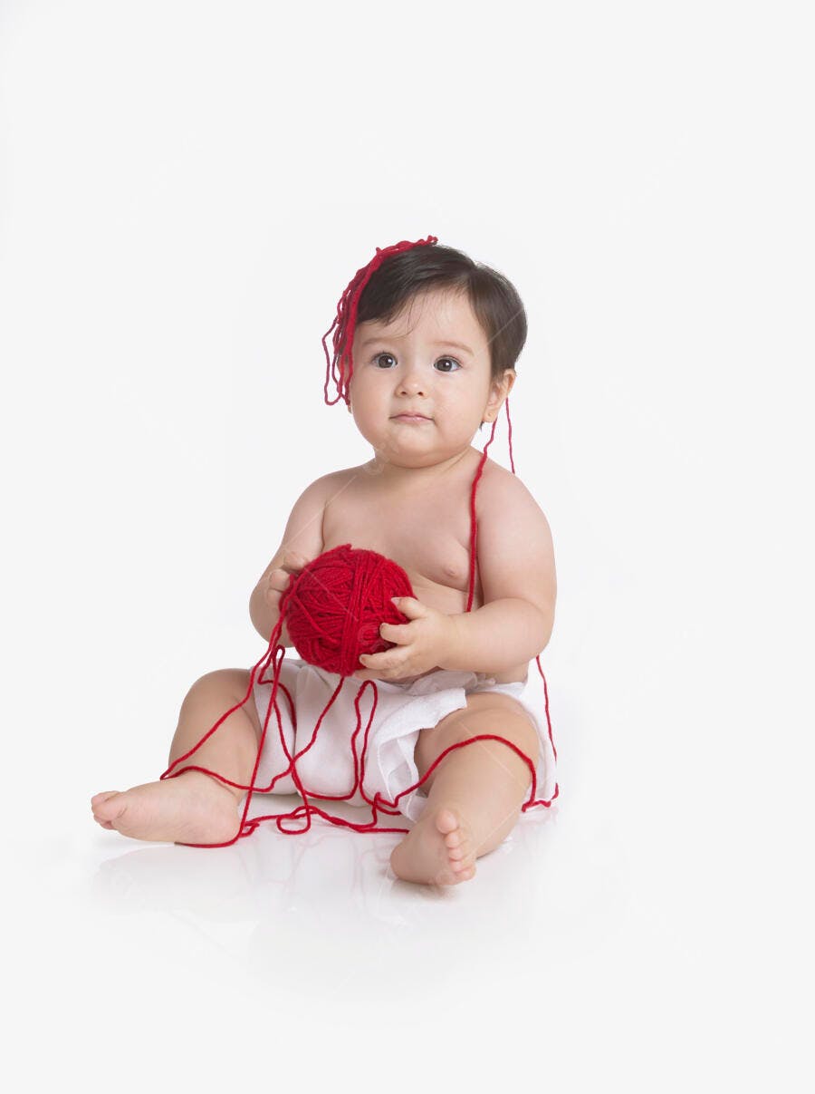 Bebê brincando com novelo vermelho