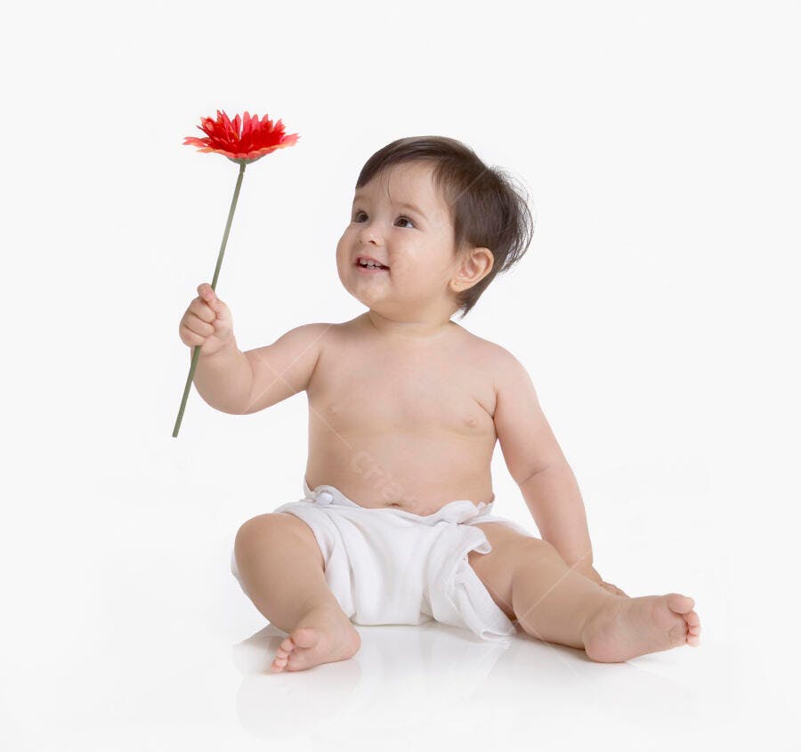 Bebê sorrindo segurando flor vermelha