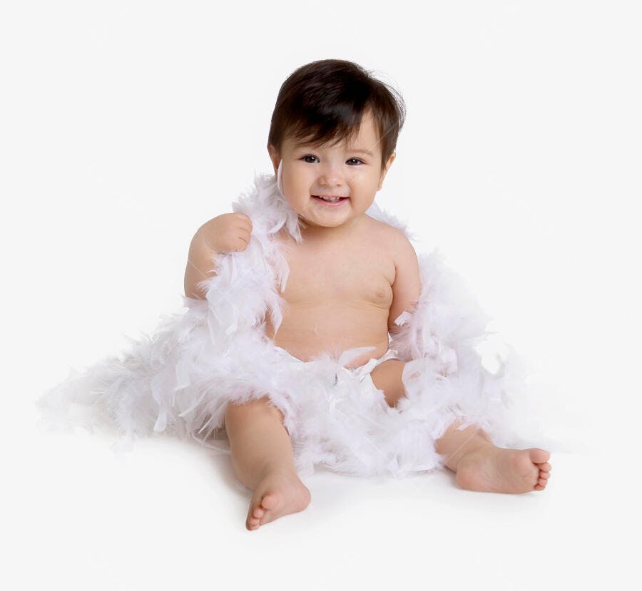 Bebê sorridente com plumas brancas