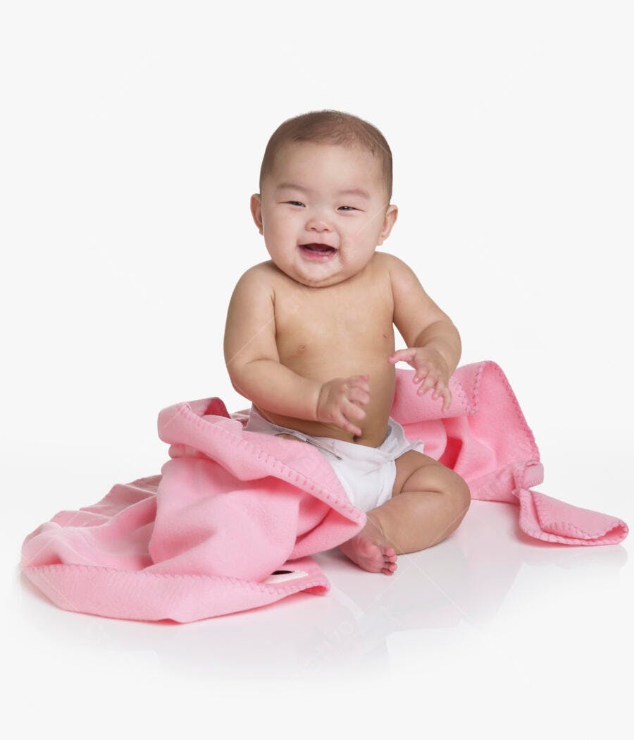 Bebê asiático sorrindo com manta rosa