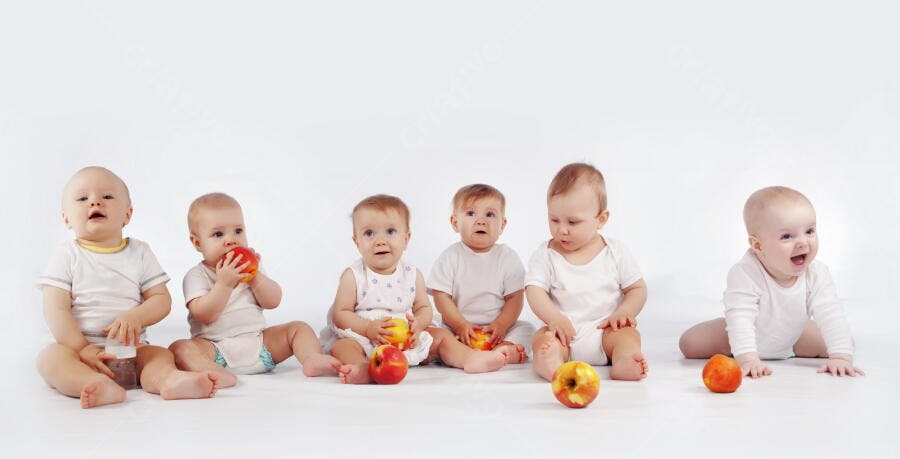 Bebês com maçãs em estúdio branco