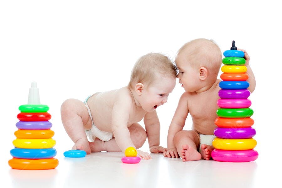 Bebês brincando com brinquedos coloridos