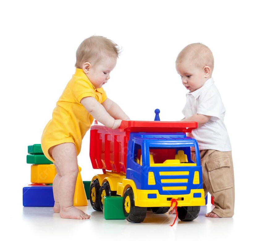 Bebês brincando com caminhão de brinquedo