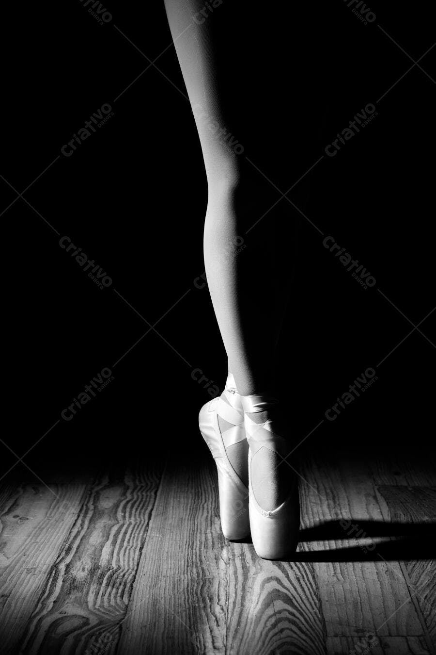 Pés de bailarina em pontas em palco escuro