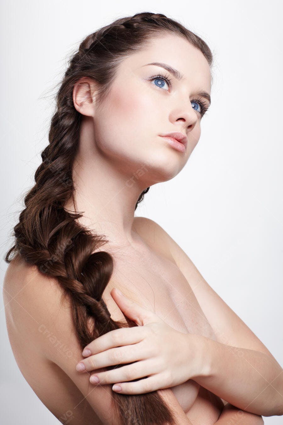 Mulher com trança castanho-claro e olhos azuis