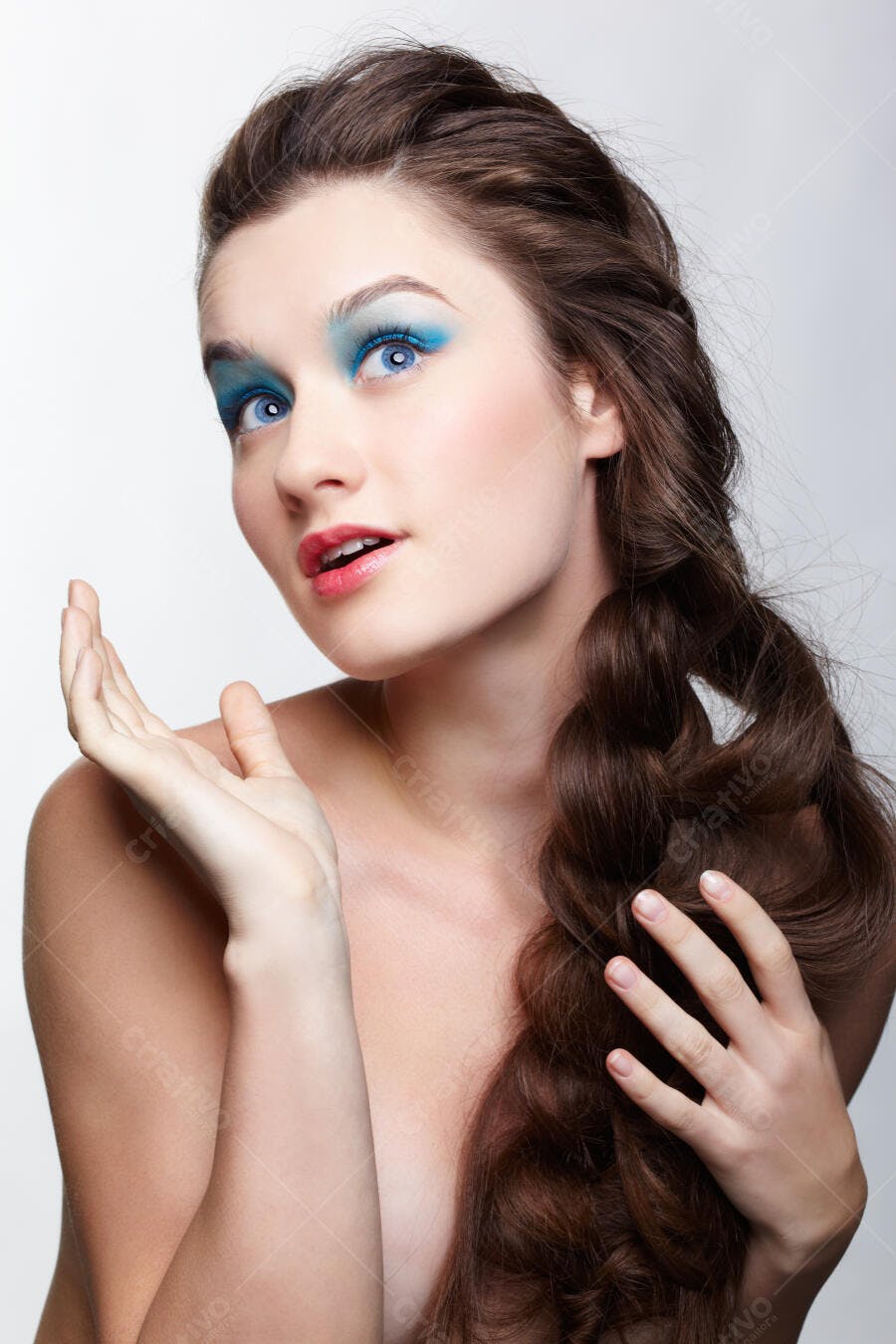 Modelo com maquiagem azul e cabelo trançado