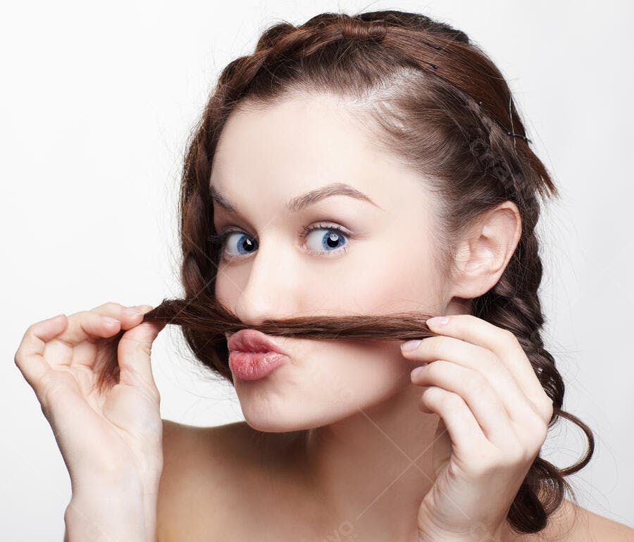 Mulher jovem com bigode de cabelo brincando