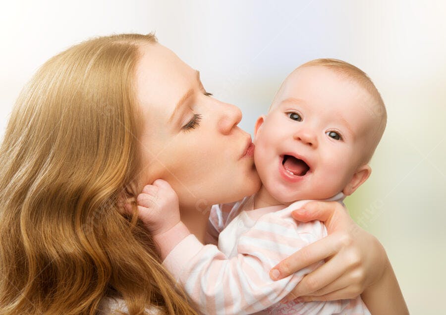 Mãe beijando bebê sorrindo